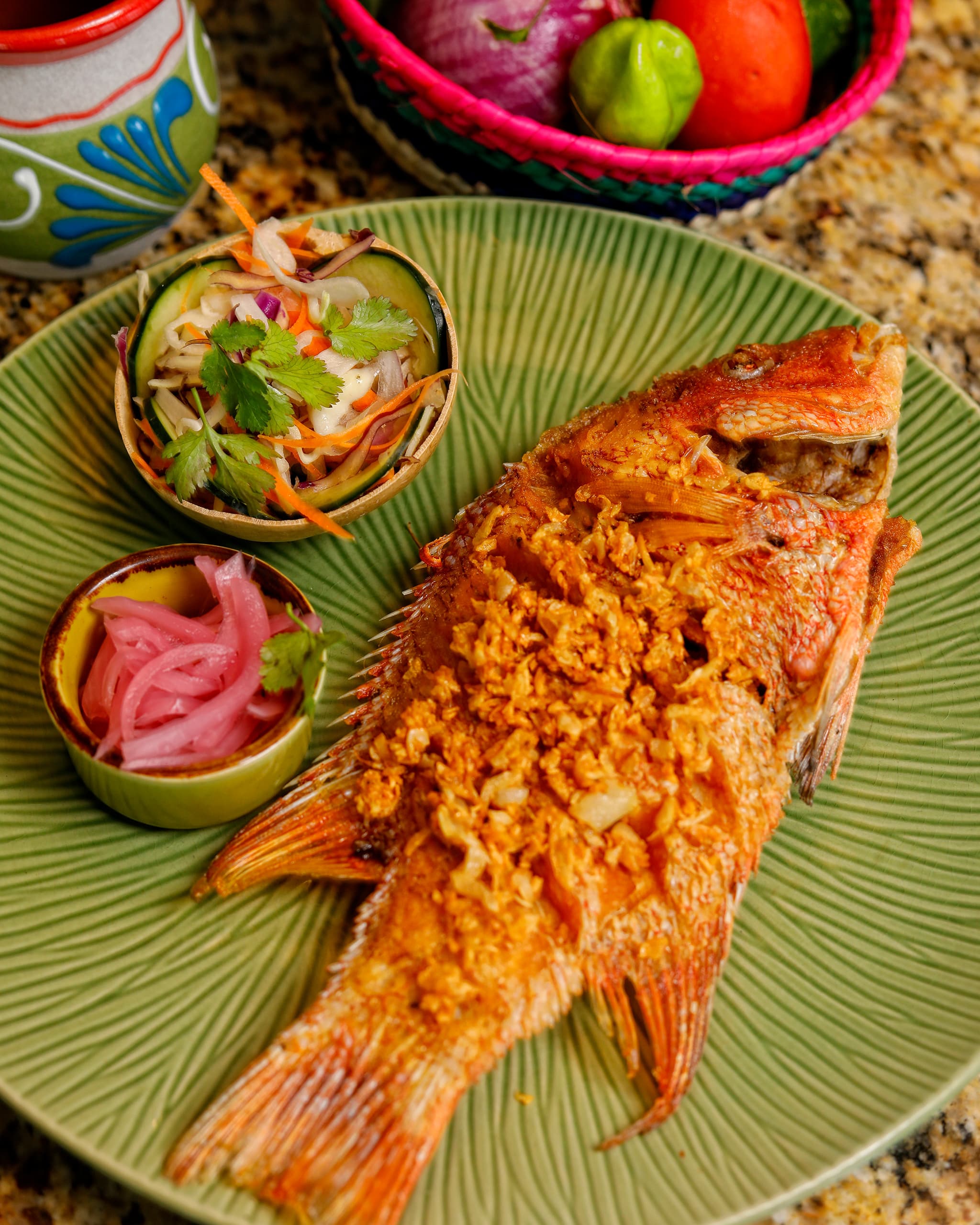 Pescado entero frito con col agria y cebolla morada encurtida