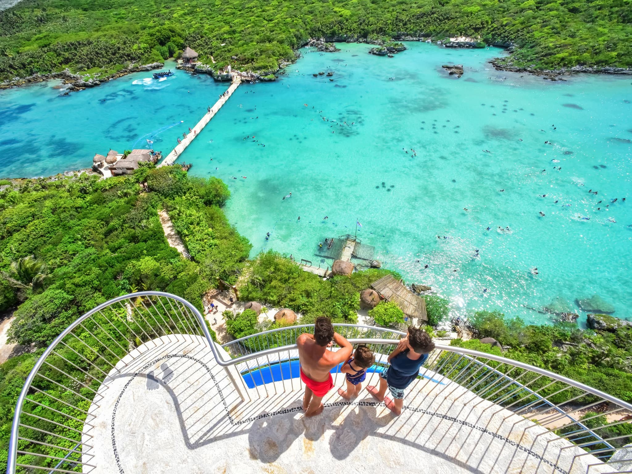 Familia en un mirador sobre una caleta turquesa