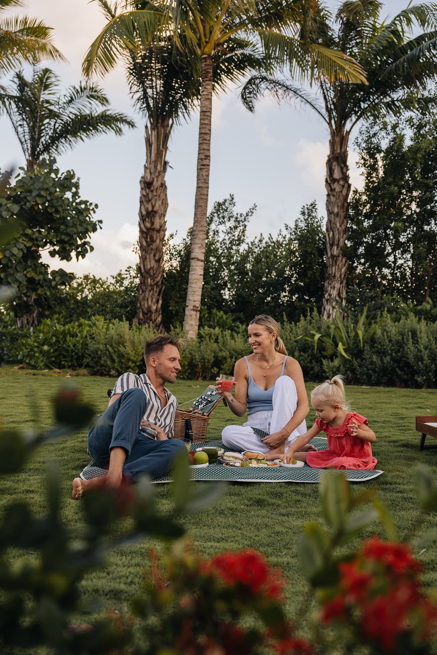 Familia de picnic en un jardín tropical