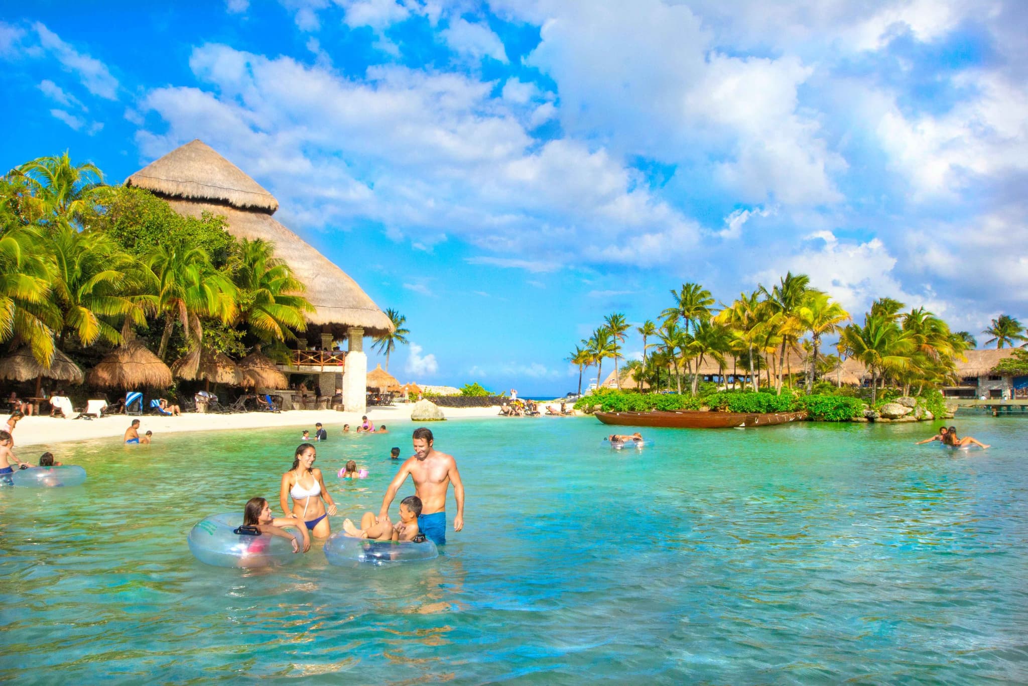Familia con niños flotando en una caleta de agua transparente
