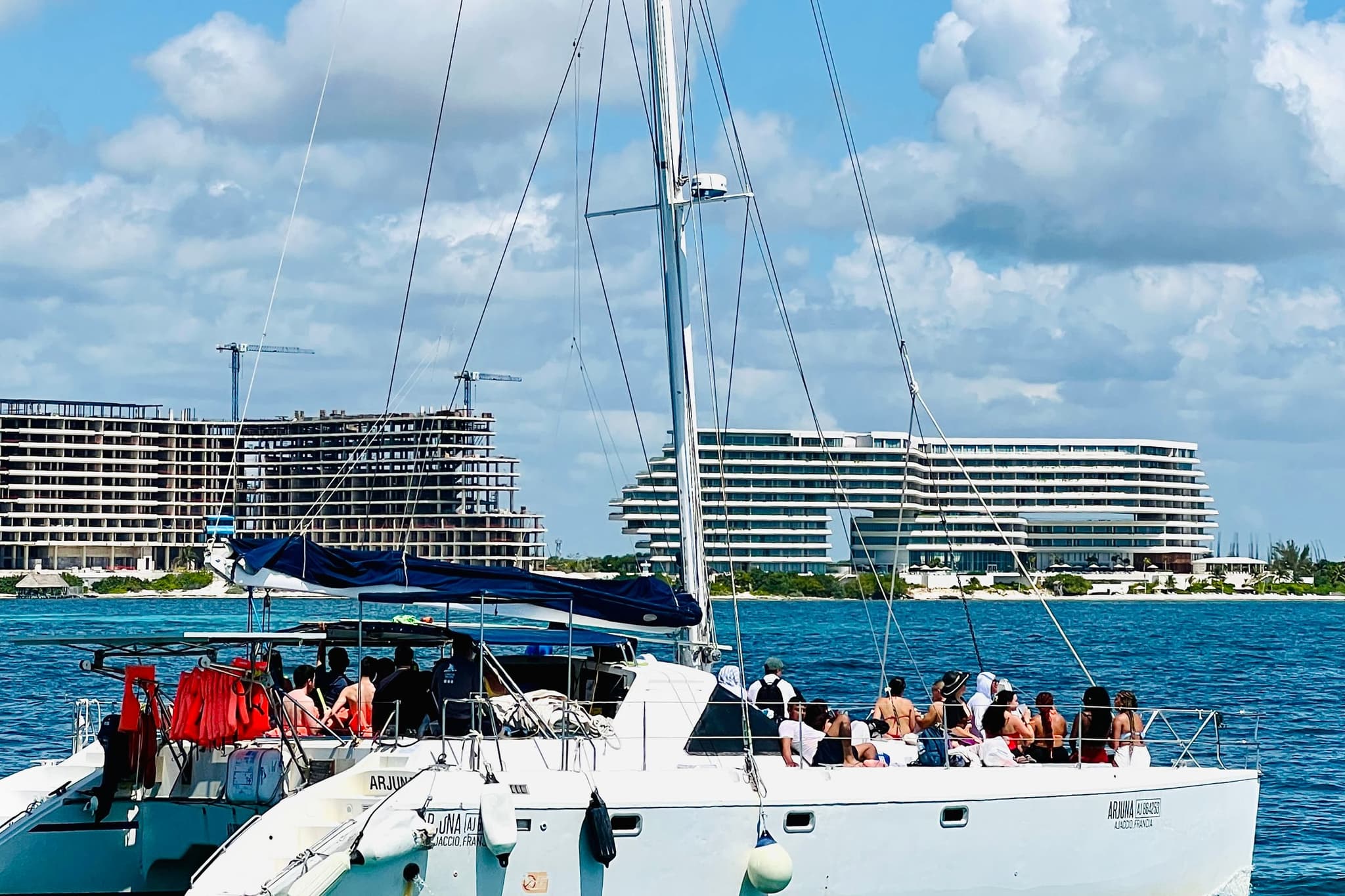 Embarcación con pasajeros cruzando el mar Caribe frente a la zona hotelera de Cancún