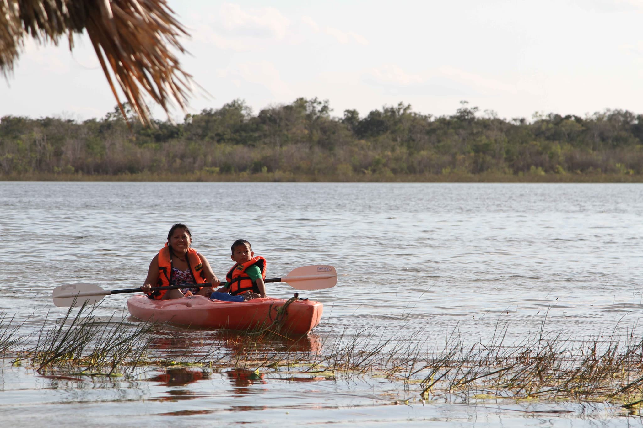 Madre e hijo remando en kayak por una laguna de Maya Ka'an