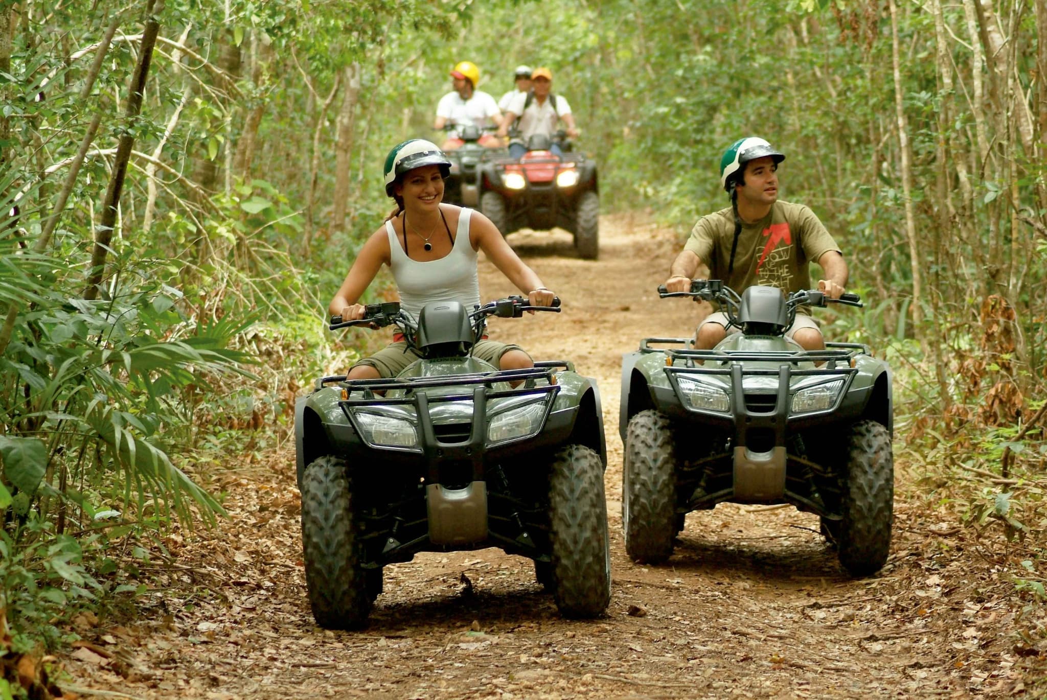 Grupo recorriendo un sendero de selva en cuatrimotos