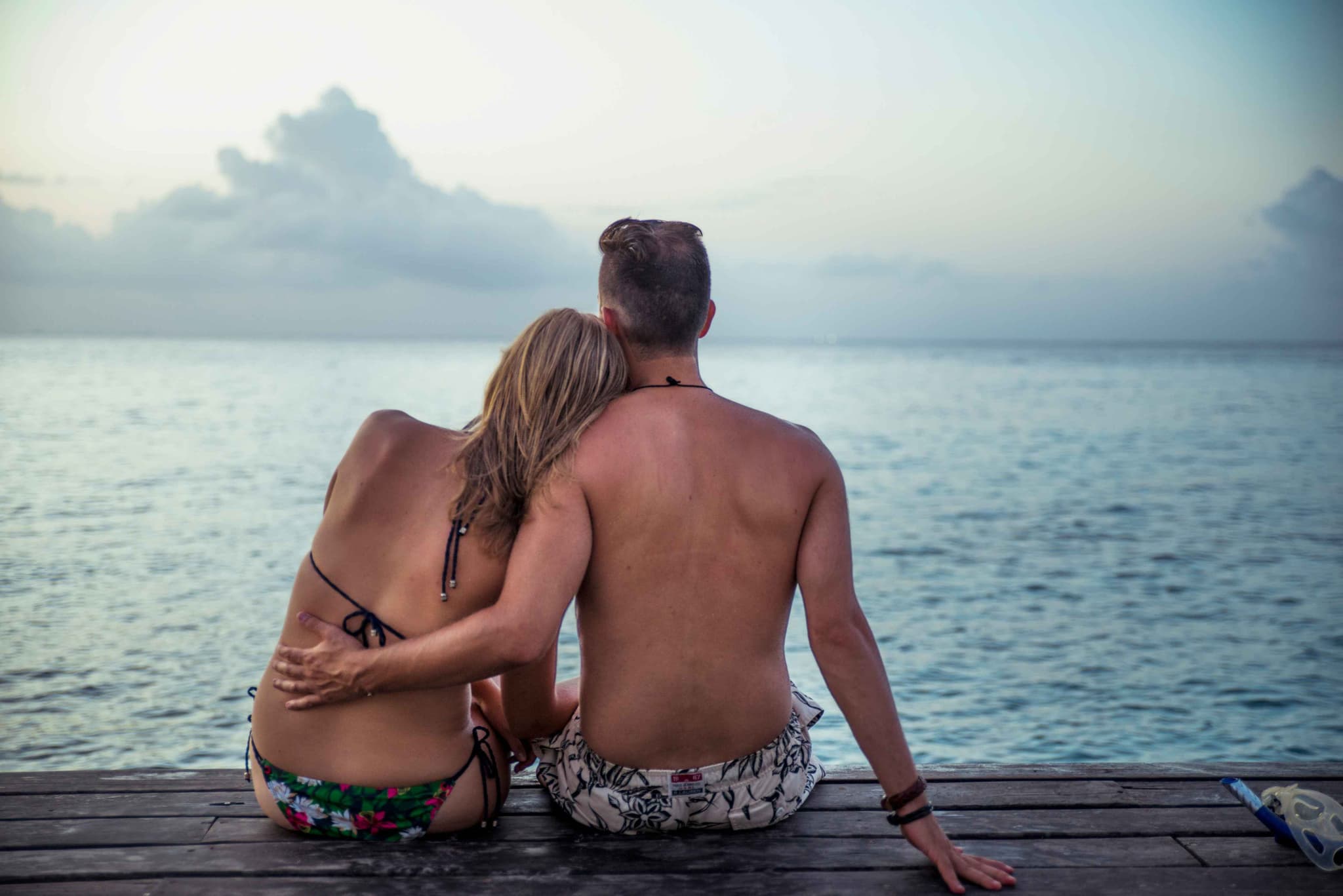 Pareja abrazada en un muelle de madera al atardecer en Cozumel