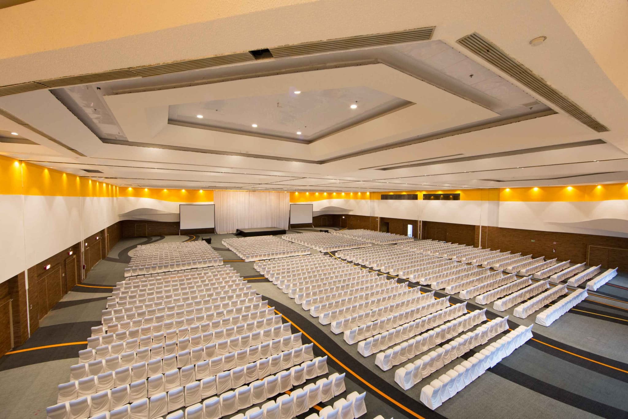 Auditorio montado con filas de sillas vestidas de blanco
