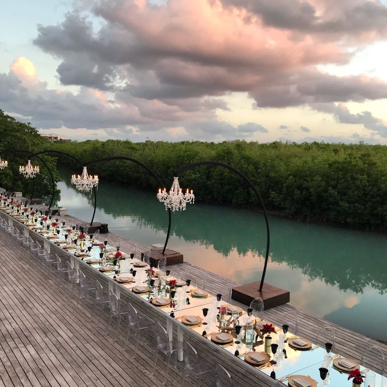 Montaje de cena junto al agua con candelabros