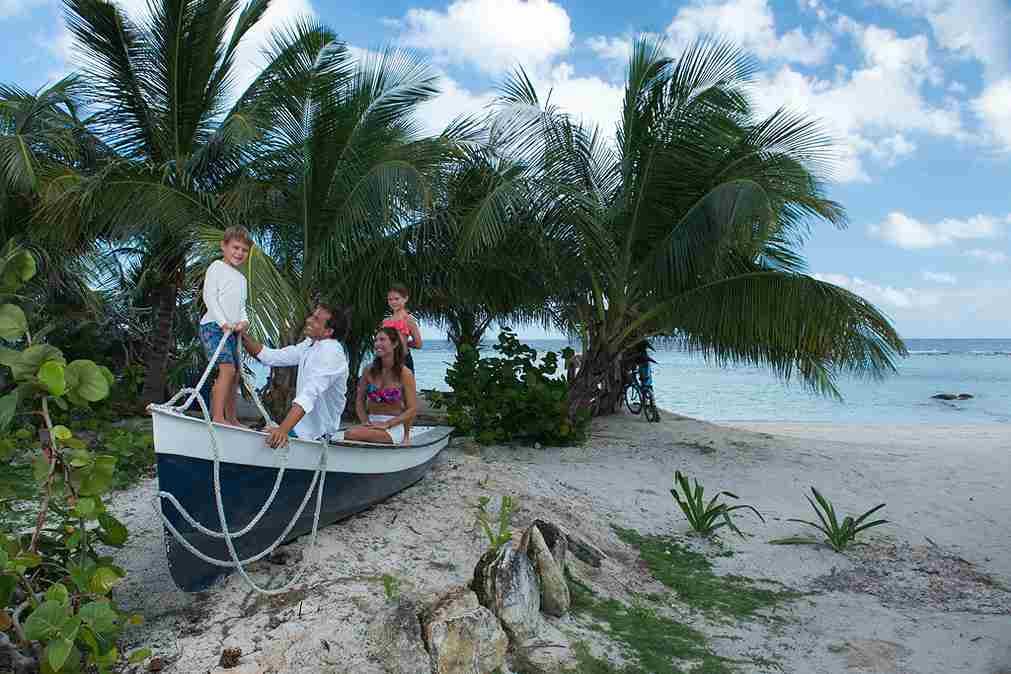 Familia con una lancha en una playa de la bahía