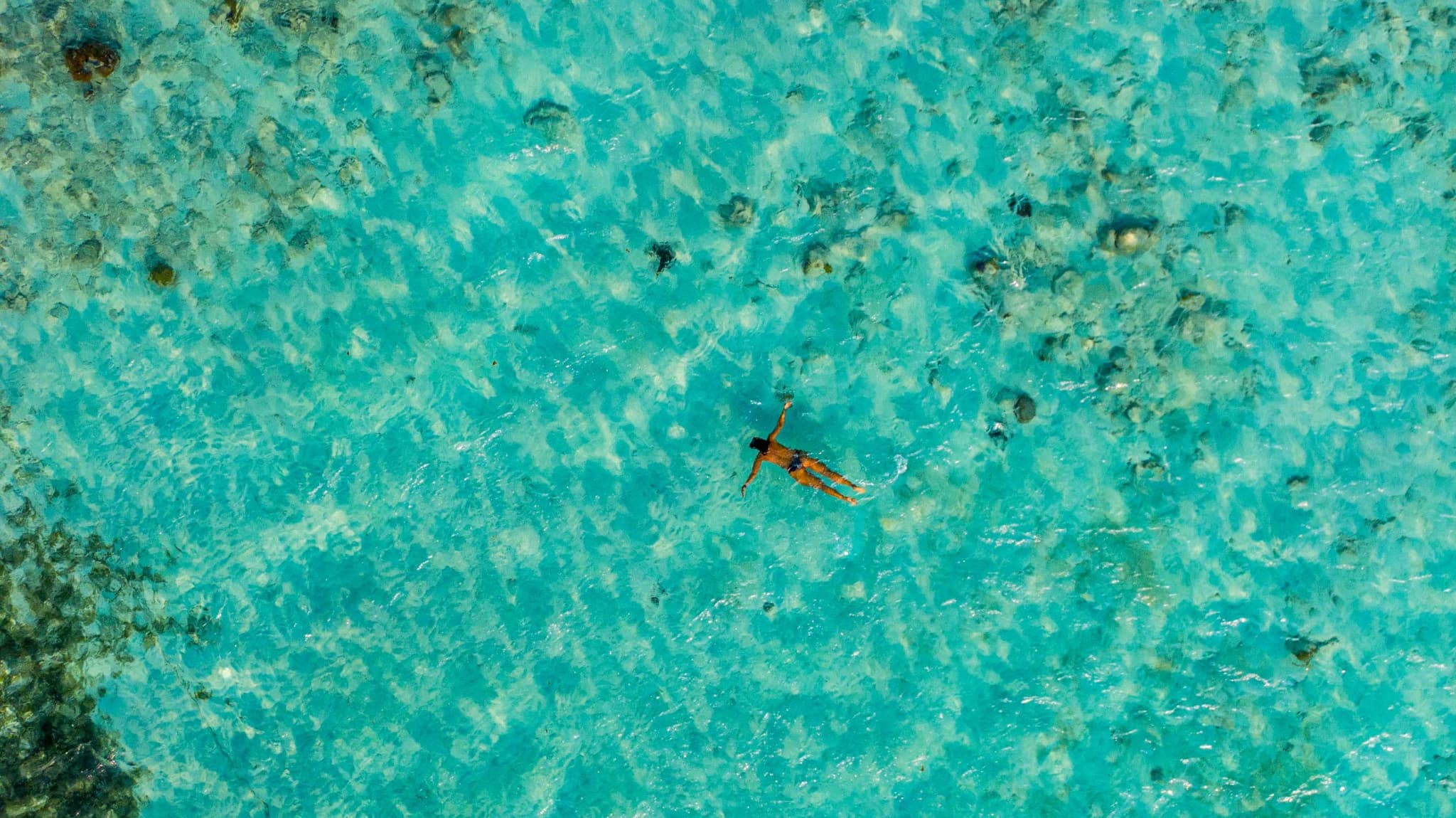 Persona flotando sobre aguas turquesa poco profundas