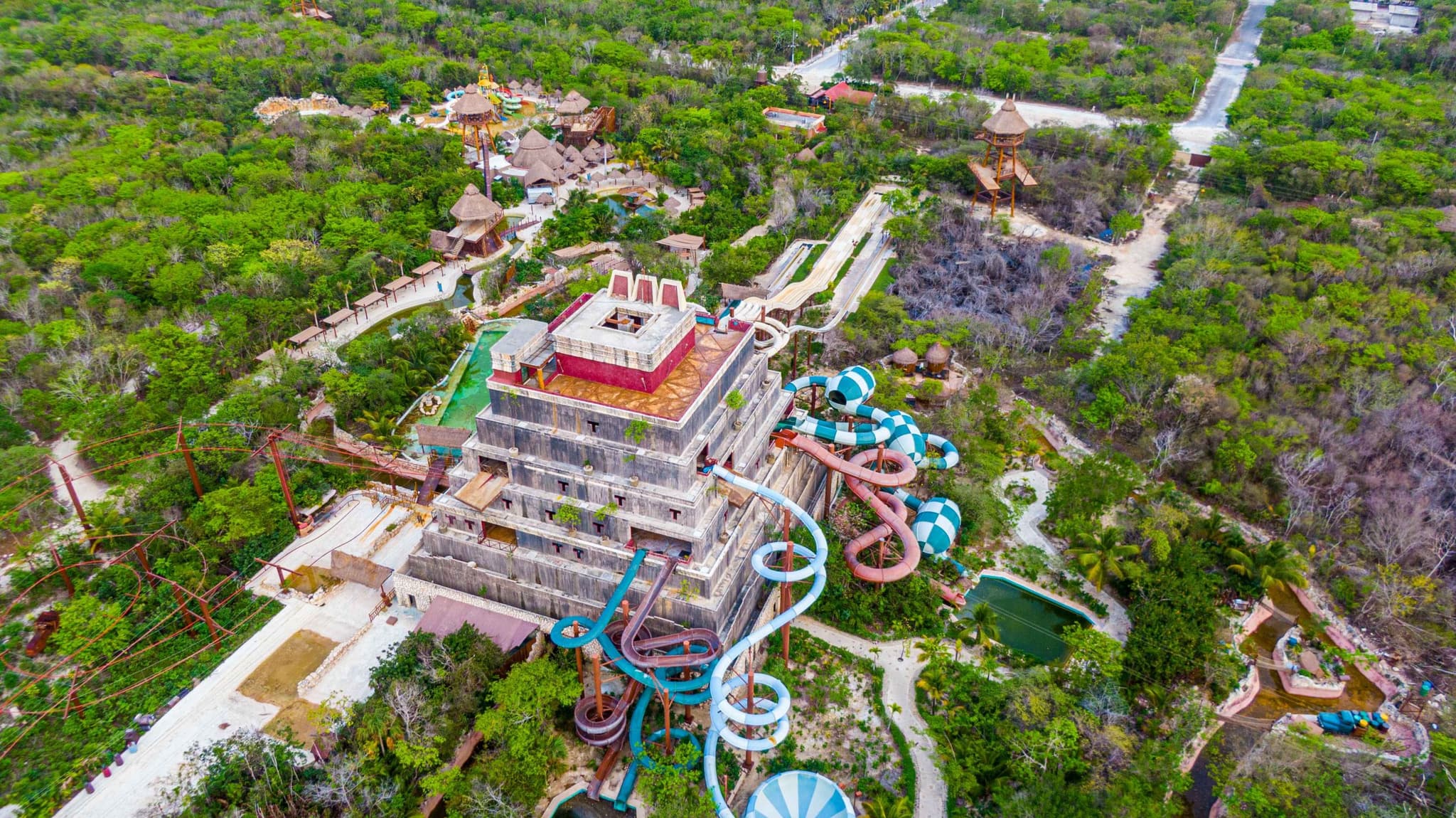 Vista aérea de un parque acuático con toboganes y una pirámide en la selva de Mahahual