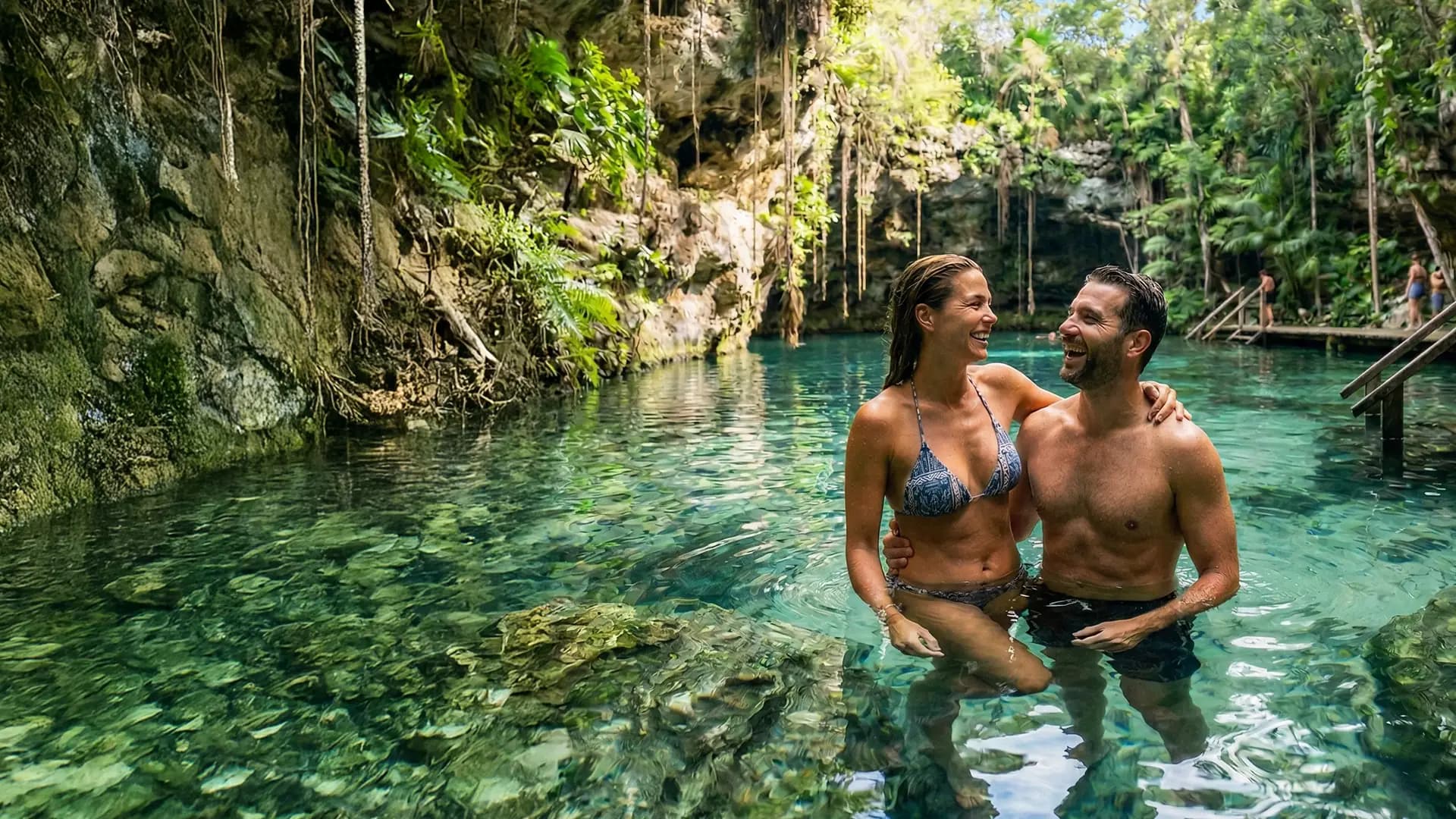 Una pareja dentro del agua verde de un cenote abierto