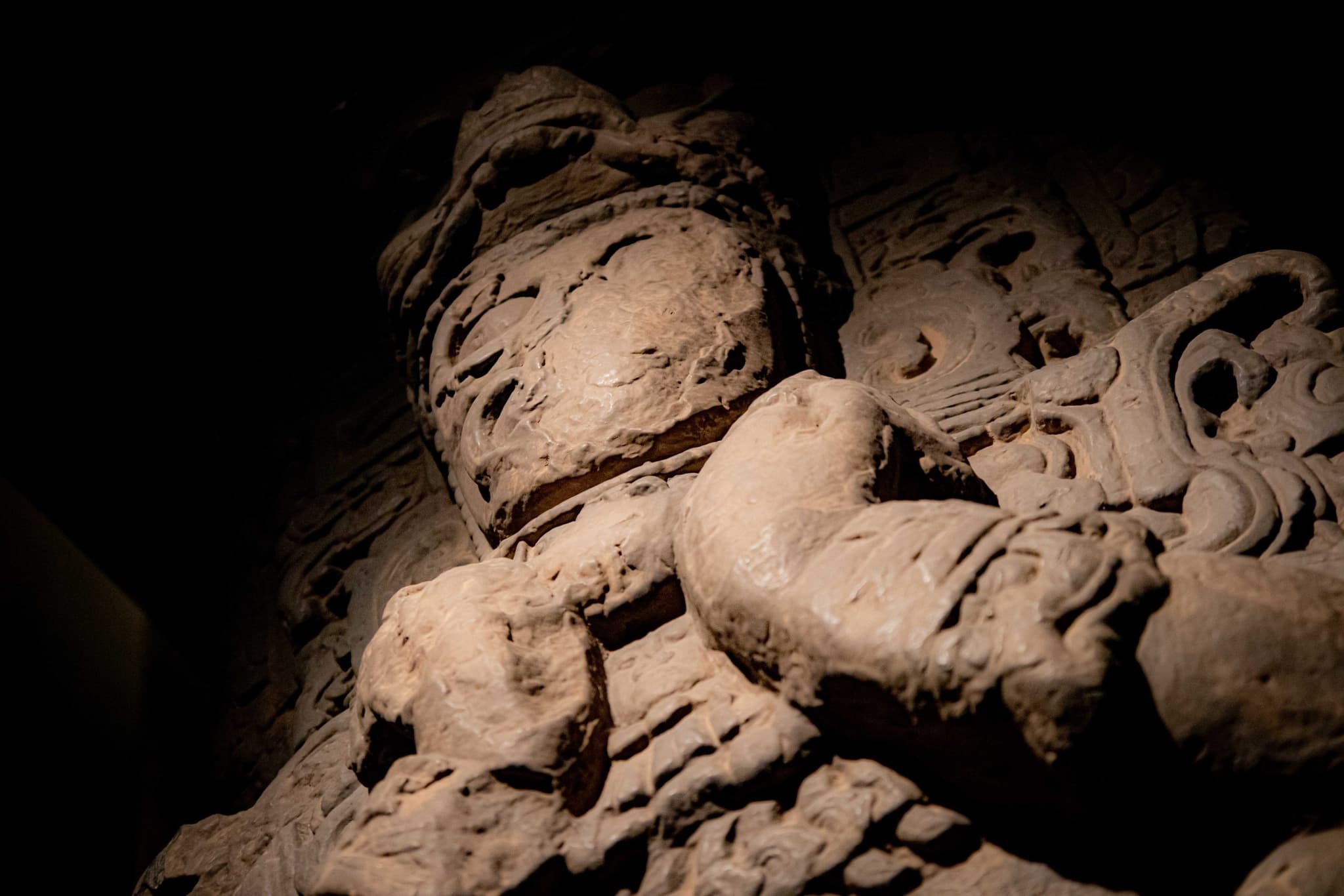 Mascarón de estuco maya iluminado en el museo