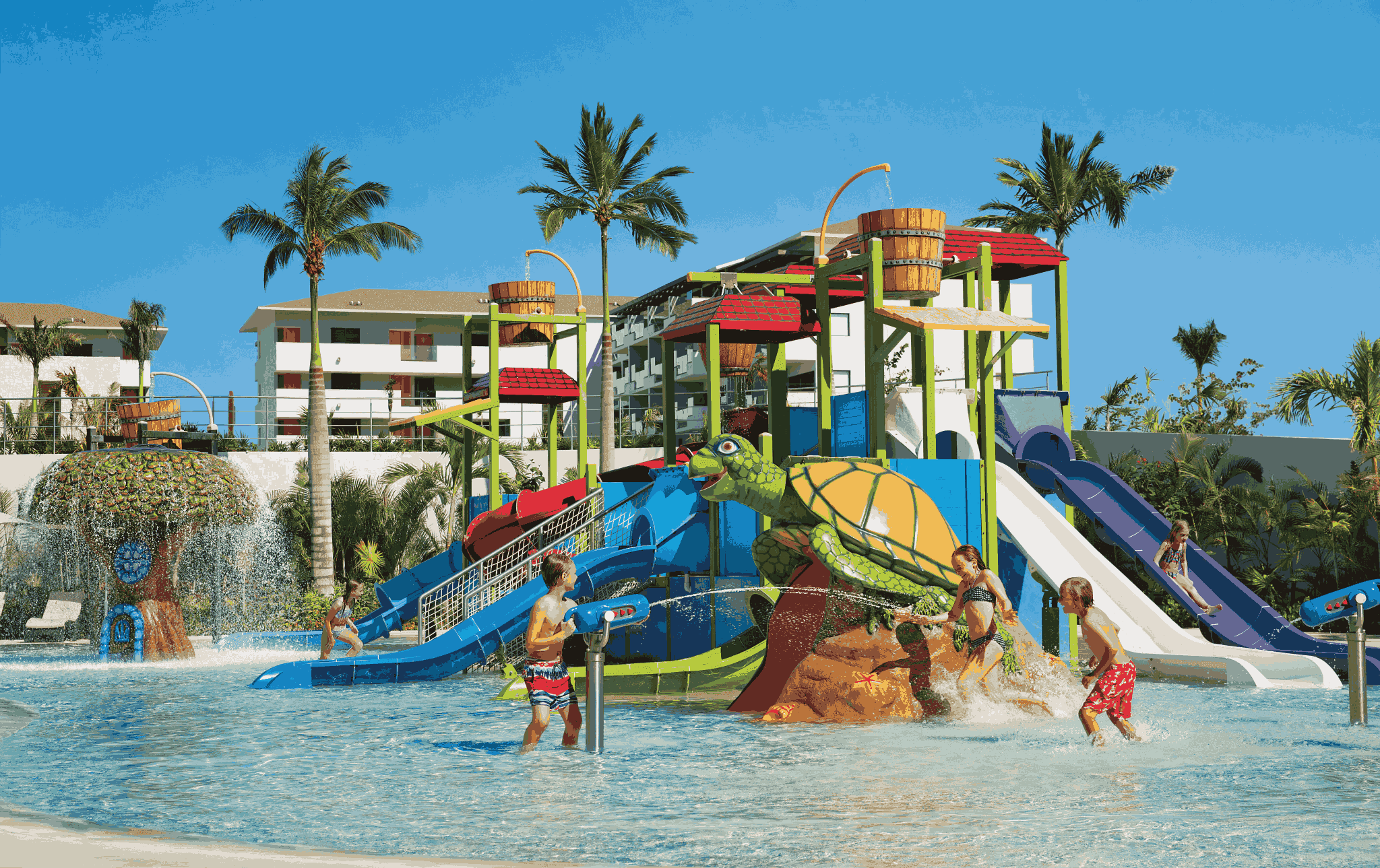 Niños bajando por los toboganes de un parque acuático de la Riviera Maya