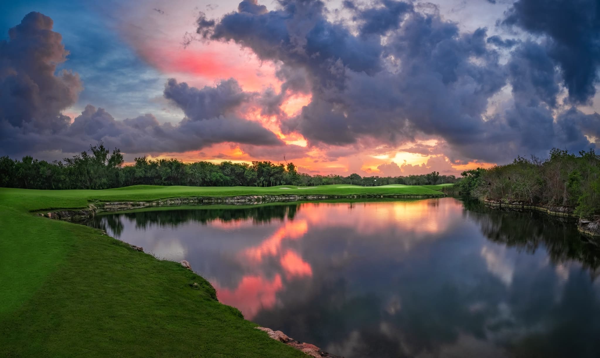 Campo de golf al amanecer junto a un lago