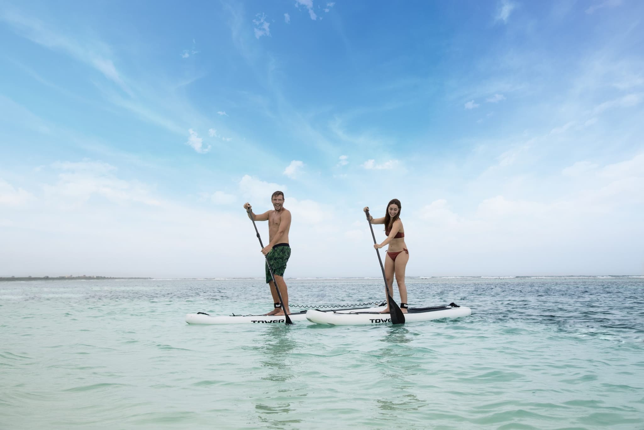 Pareja en tablas de paddle frente a Mahahual